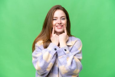 Genç ve güzel bir kadın izole edilmiş krom anahtar arka planda mutlu ve hoş bir ifadeyle gülümsüyor.