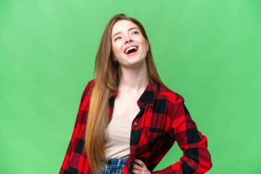 Genç ve güzel bir kadın izole edilmiş krom anahtar arka planı gülüyor.