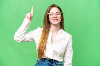 Young pretty woman over isolated chroma key background pointing up a great idea