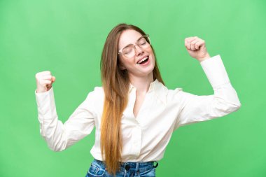 Young pretty woman over isolated chroma key background celebrating a victory