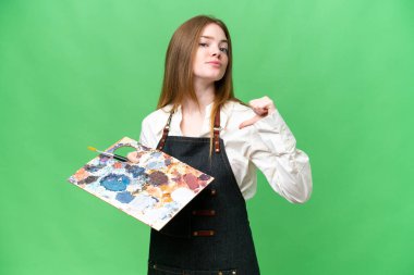 Young artist woman holding a palette over isolated chroma key background proud and self-satisfied
