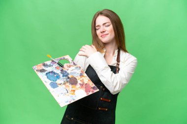 Young artist woman holding a palette over isolated chroma key background suffering from pain in shoulder for having made an effort
