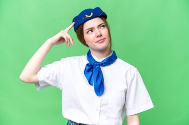 Airplane stewardess over isolated chroma key background having doubts and with confuse face expression