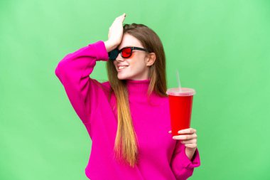 Young woman holding soda while watching a 3D movie has realized something and intending the solution
