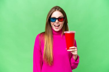 Young woman holding soda while watching a 3D movie with surprise and shocked facial expression
