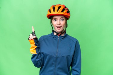 Young cyclist woman over isolated chroma key background thinking an idea pointing the finger up