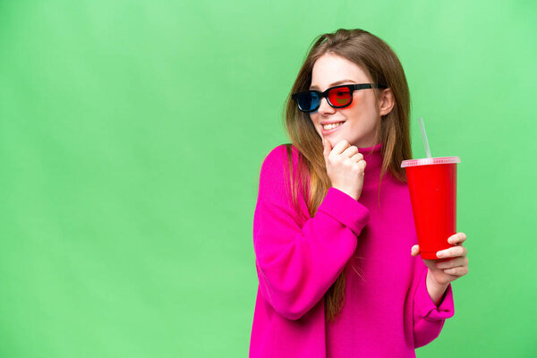 Young woman holding soda while watching a 3D movie thinking an idea and looking side