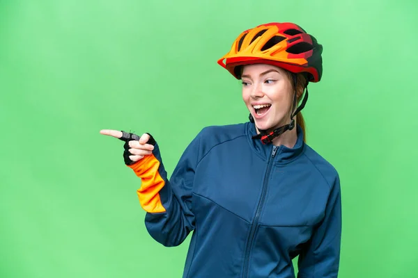 Young Cyclist Woman Isolated Chroma Key Background Pointing Finger Side — Stockfoto