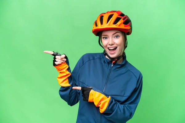 Young Cyclist Woman Isolated Chroma Key Background Surprised Pointing Side — Stockfoto