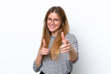 Beyaz arka planda izole edilmiş genç beyaz kadın şaşırmış ve ön tarafı işaret ediyor.