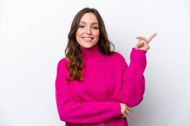 Beyaz arka planda izole edilmiş genç beyaz kadın mutlu ve yukarıya bakıyor.