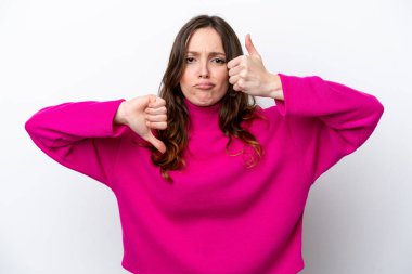 Beyaz arka planda izole edilmiş beyaz bir kadın iyiye-kötüye işaret yapıyor. Evet ya da hayır arasında kararsız