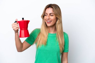 Young Uruguayan woman holding coffee pot isolated on white background with happy expression