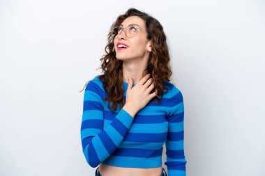 Beyaz arka planda izole edilmiş genç beyaz kadın gülümserken yukarı bakıyor.