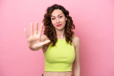 Pembe arka planda izole edilmiş beyaz kadın parmaklarıyla beşi sayıyor.