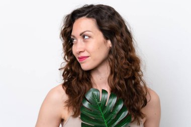 Beyaz arka planda, elinde palmiye yaprağı olan beyaz bir kadın. Portreyi kapat