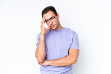 Beyaz arka planda başı ağrıyan genç beyaz bir adam.