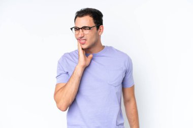 Beyaz arka planda diş ağrısı çeken beyaz tenli genç bir adam.