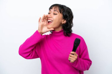 Young Argentinian singer woman isolated on white background shouting with mouth wide open to the side