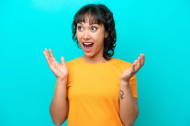Young Argentinian woman isolated on blue background with surprise facial expression