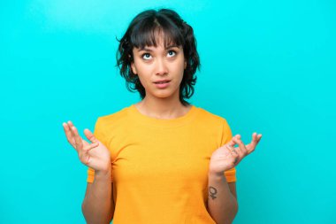 Young Argentinian woman isolated on blue background stressed overwhelmed