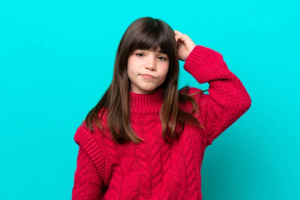 Little caucasian girl isolated on blue background with an expression of frustration and not understanding