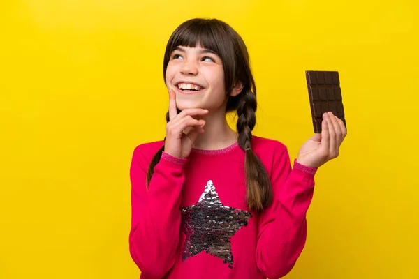 Malá Kavkazská Dívka Čokoládou Izolované Žlutém Pozadí Myšlení Nápad Při — Stock fotografie
