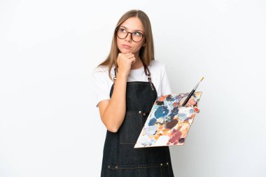 Litvanyalı genç bir kadın beyaz arka planda izole edilmiş bir palet tutuyor ve yukarı bakıyor.