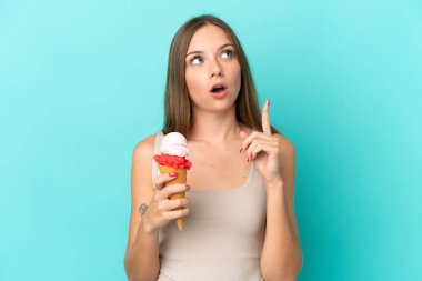 Young Lithuanian woman with cornet ice cream isolated on blue background thinking an idea pointing the finger up