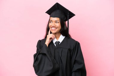 Young university Colombian woman graduate isolated on pink background thinking an idea while looking up
