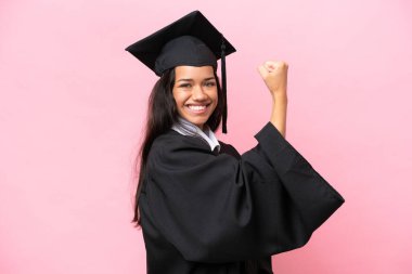 Young university Colombian woman graduate isolated on pink background doing strong gesture
