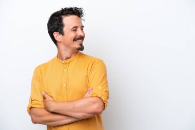 Bıyıklı genç adam beyaz arka planda izole edilmiş, kolları bağlı ve mutlu.