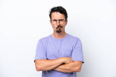 Bıyıklı genç adam, mutsuz bir ifadeyle beyaz arka planda izole edilmiş.
