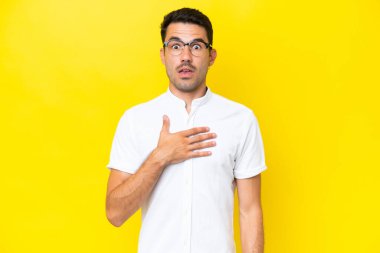 Sarı arka planda yaşayan yakışıklı genç adam sağa bakarken şaşırdı ve şok oldu.