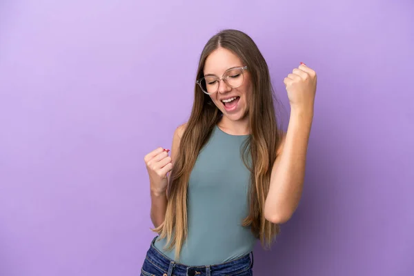 Young Lithuanian woman isolated on purple background celebrating a victory