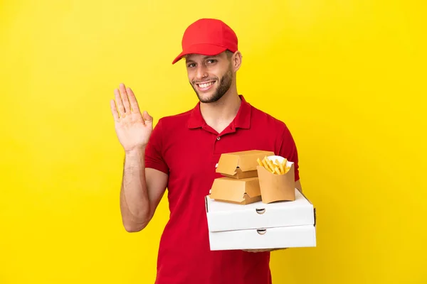 Repartidor Pizza Recogiendo Cajas Pizza Hamburguesas Sobre Fondo Aislado Saludando — Foto de Stock
