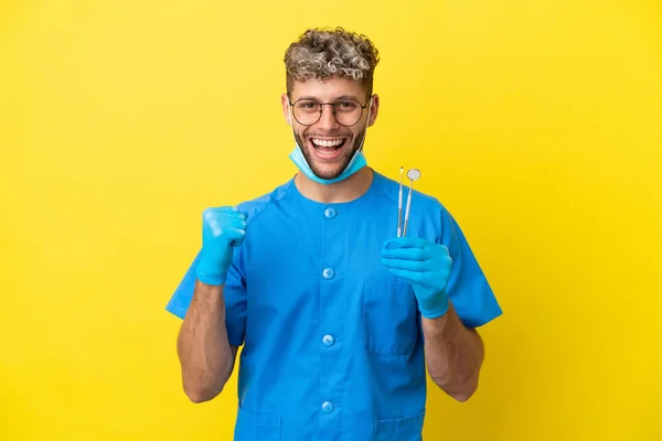 Dentista Caucasiano Homem Segurando Ferramentas Isoladas Fundo Amarelo Celebrando Uma — Fotografia de Stock