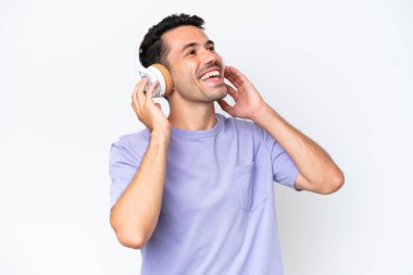 Genç yakışıklı adam soyutlanmış beyaz arka plan müzik dinliyor ve şarkı söylüyor.