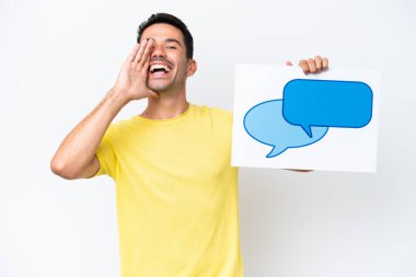 Young handsome man over isolated white background holding a placard with speech bubble icon and shouting