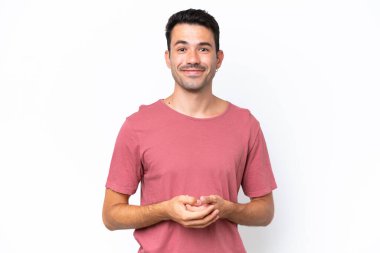 Genç yakışıklı, soyutlanmış beyaz arka plan gülüyor.