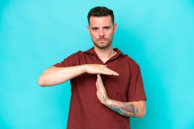 Beyaz tenli yakışıklı adam mavi arka planda izole edilmiş.