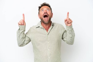 Beyaz arka planda izole edilmiş orta yaşlı beyaz bir adam şaşırmış ve işaret ediyor.