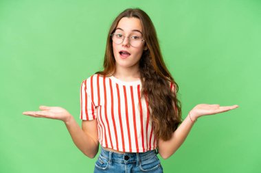 Teenager girl over isolated chroma key background with shocked facial expression