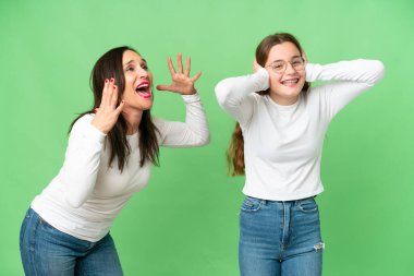 mother and daughter over isolated chroma key background frustrated and shouting