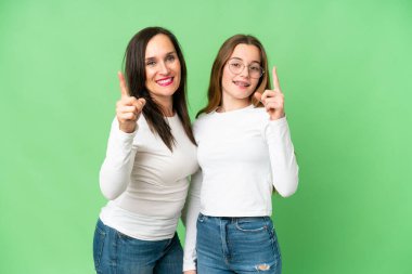 mother and daughter over isolated chroma key background intending to realizes the solution while lifting a finger up