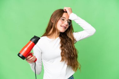 Teenager girl holding a hairdryer over isolated chroma key background has realized something and intending the solution