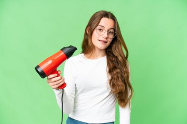Teenager girl holding a hairdryer over isolated chroma key background with happy expression