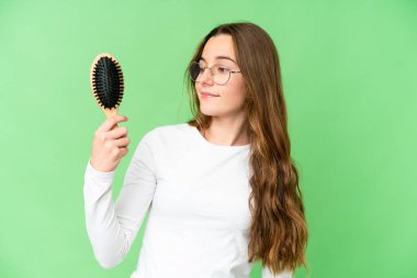 Teenager girl with hair comb over isolated chroma key background with happy expression