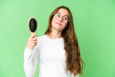 Teenager girl with hair comb over isolated chroma key background looking up while smiling