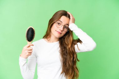 Teenager girl with hair comb over isolated chroma key background has realized something and intending the solution